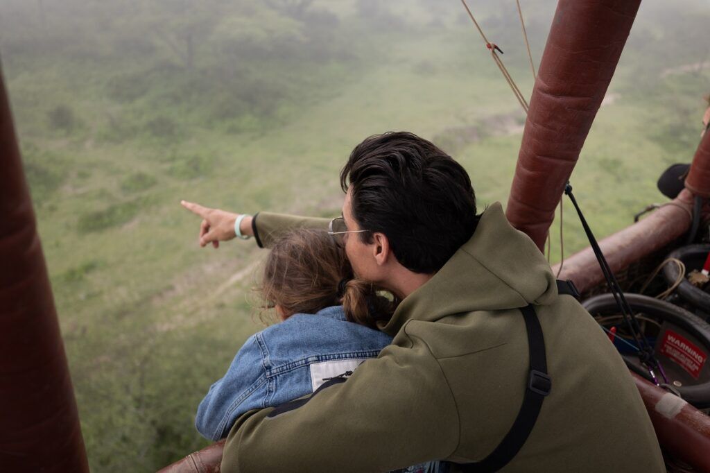Man en kind kijken naar het uitzicht vanuit een luchtballon